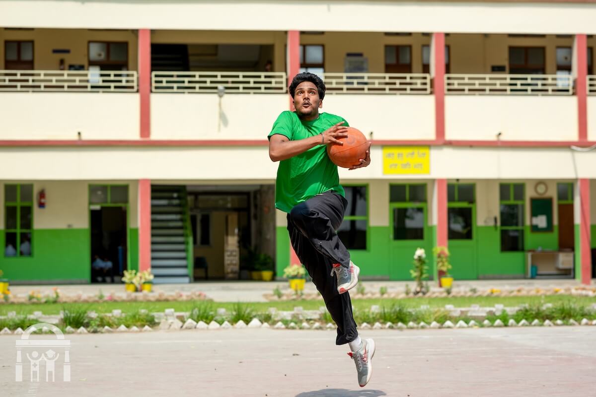 Teen playing basketball on court at Guru Nanak Mission Public School Dhahan Kaleran in Punjab