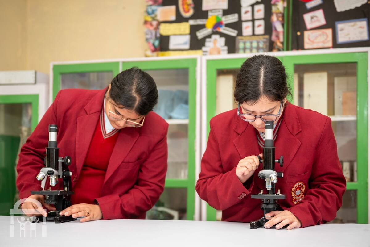 High school students in biology lab looking under microscopes at GN Public Secondary School in Dhahan Kaleran, SBS Nagar, Punjab, India