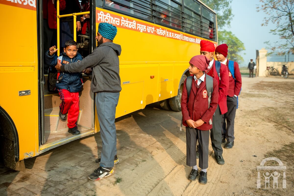 Bus driver helping child at Guru Nanak Mission Public School in Dhahan Kaleran, SBS Nagar, Punjab, India