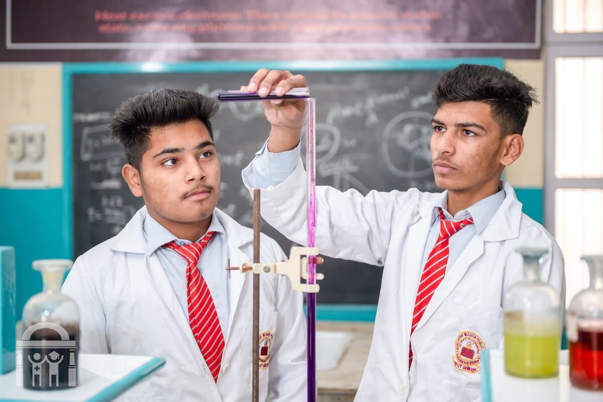 Chemistry lab high school students pouring liquid into tube at GN Public Secondary School Dhahan Kaleran, SBS Nagar, Punjab, India