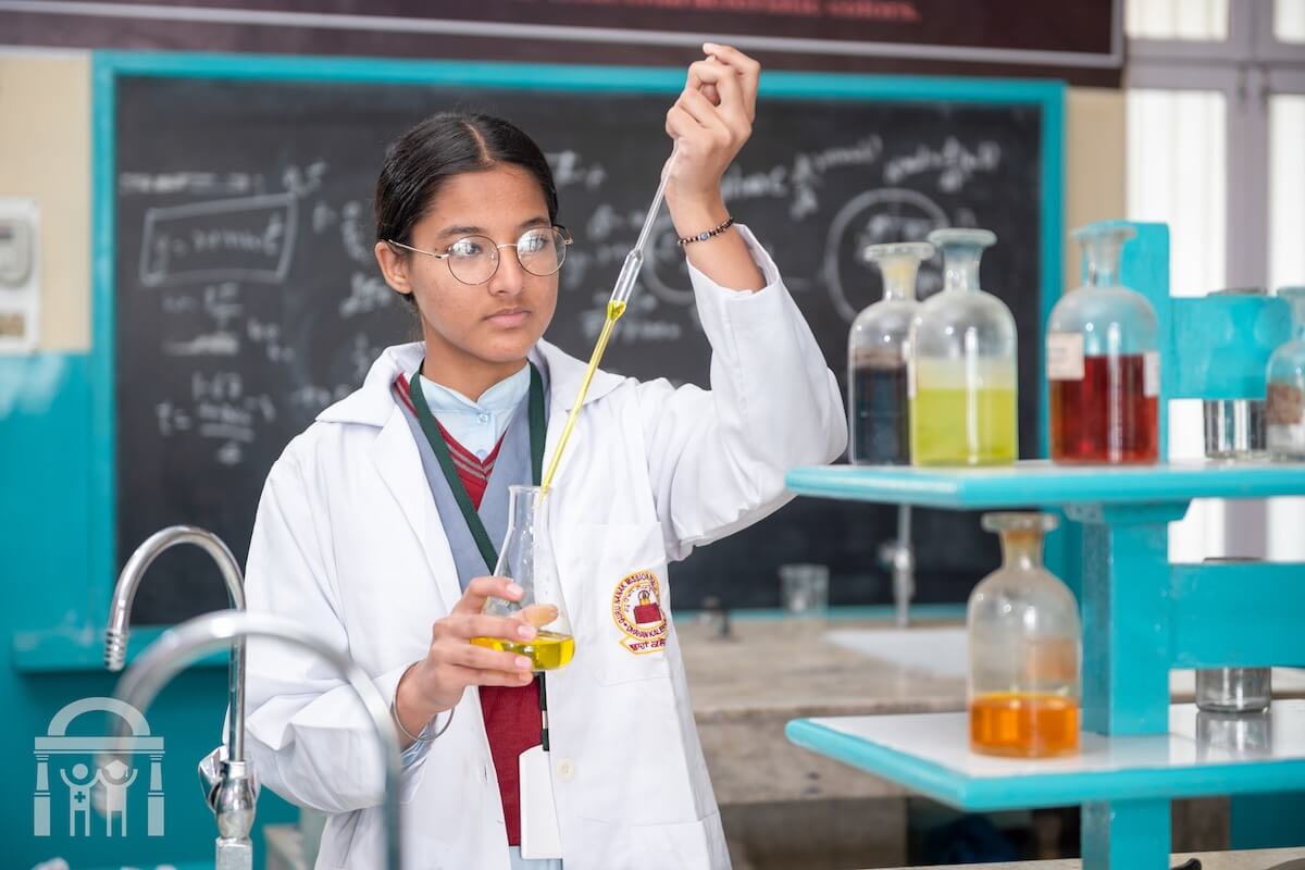 Chemistry lab - student using liquid dropper to pour in beaker - GN Public School Dhahan Kaleran, SBS Nagar, Punjab, India