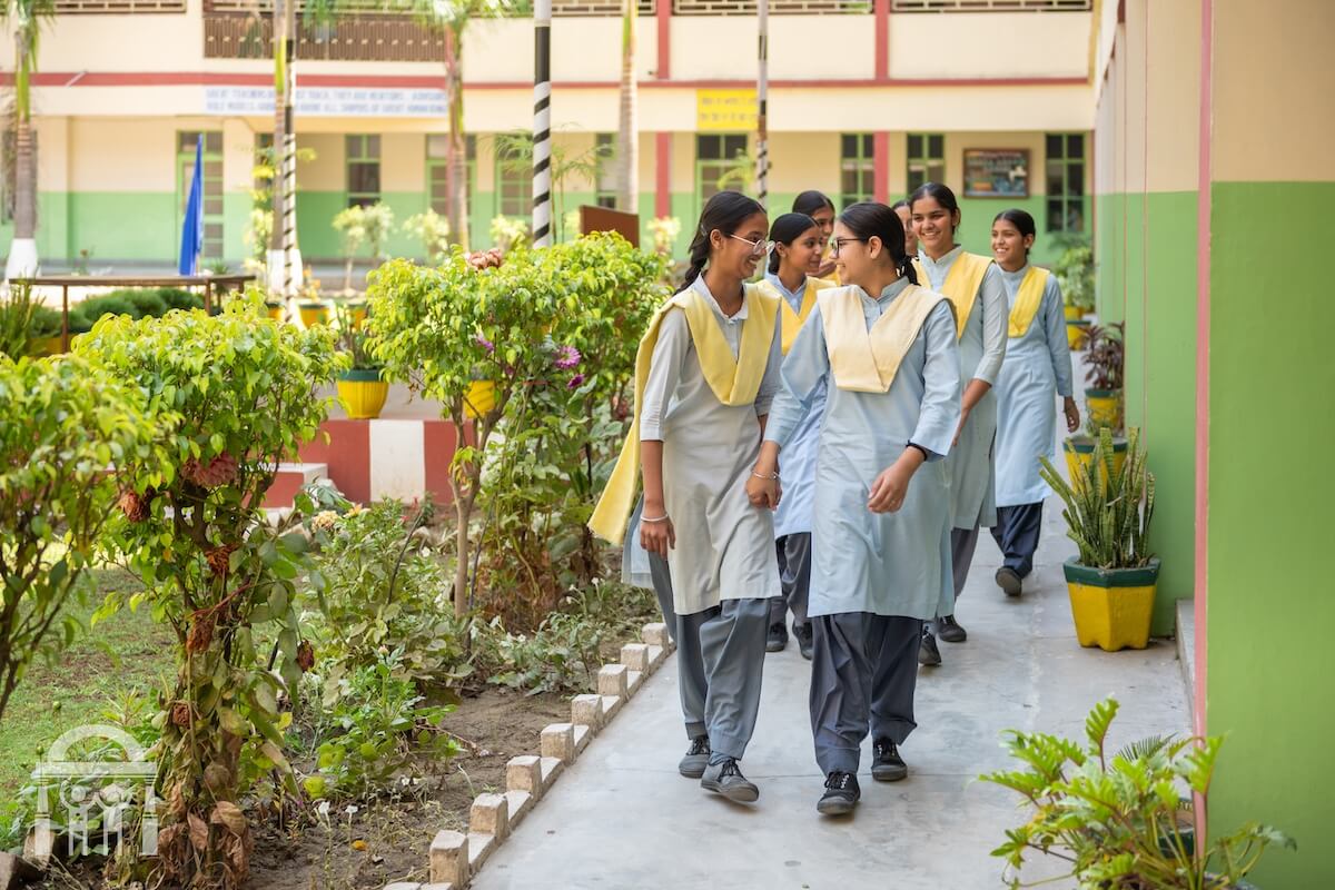 High school girls in uniform walking on campus happily at Guru Nanak Mission Public School Dhahan Kaleran, Punjab
