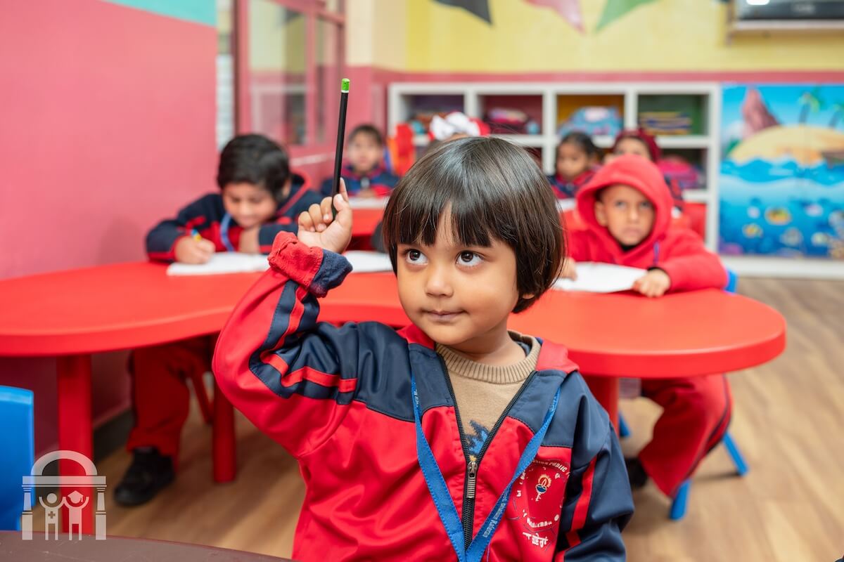 Kindergarten child raising hand in a classroom at Guru Nanak Mission Public School in Dhahan Kaleran, Punjab