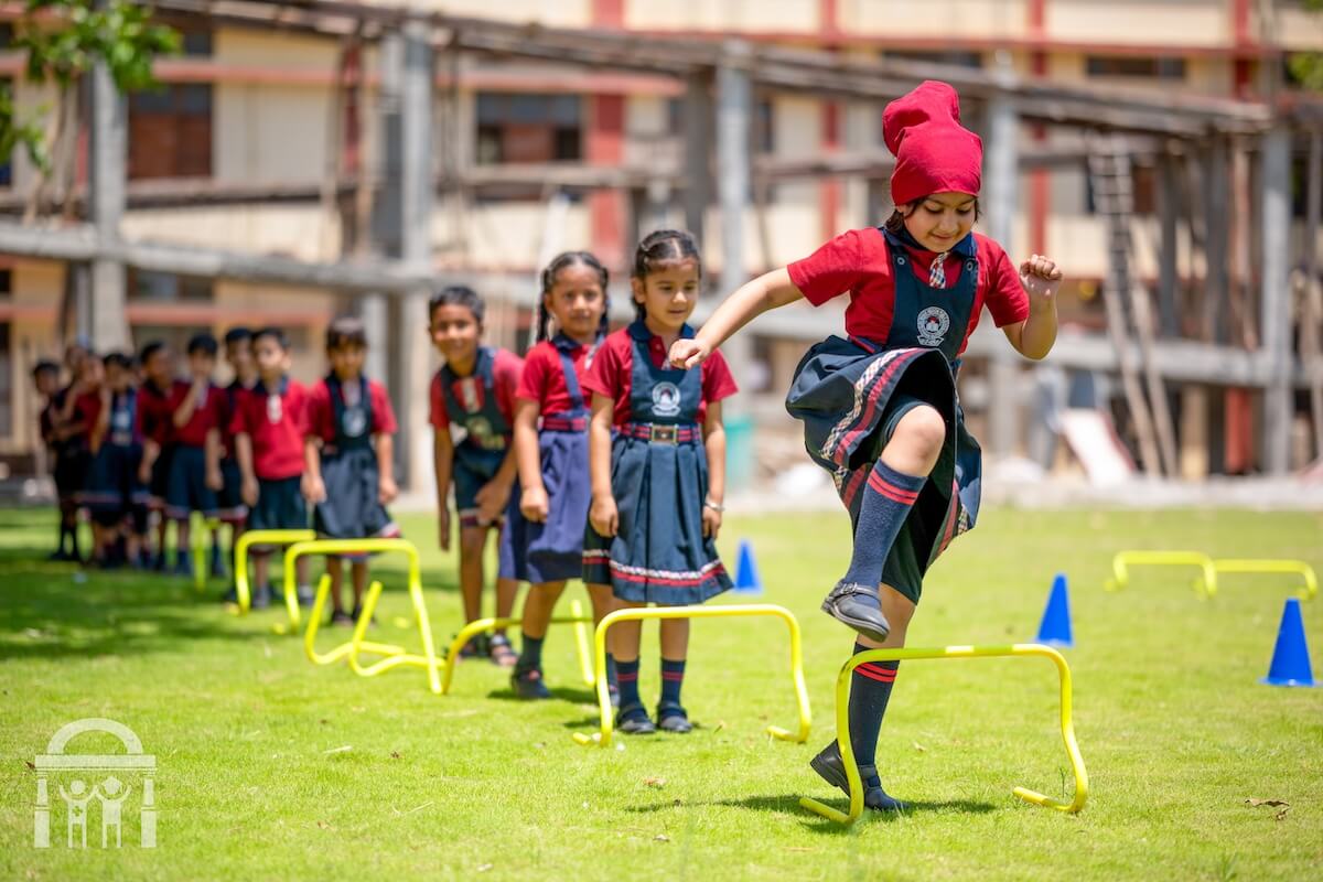 Primary school girls playing jumping game as outdoor activity at Guru Nanak Mission Public School