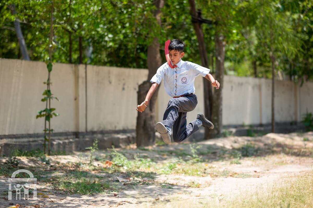Primary school boy running on field at Guru Nanak Mission Public School