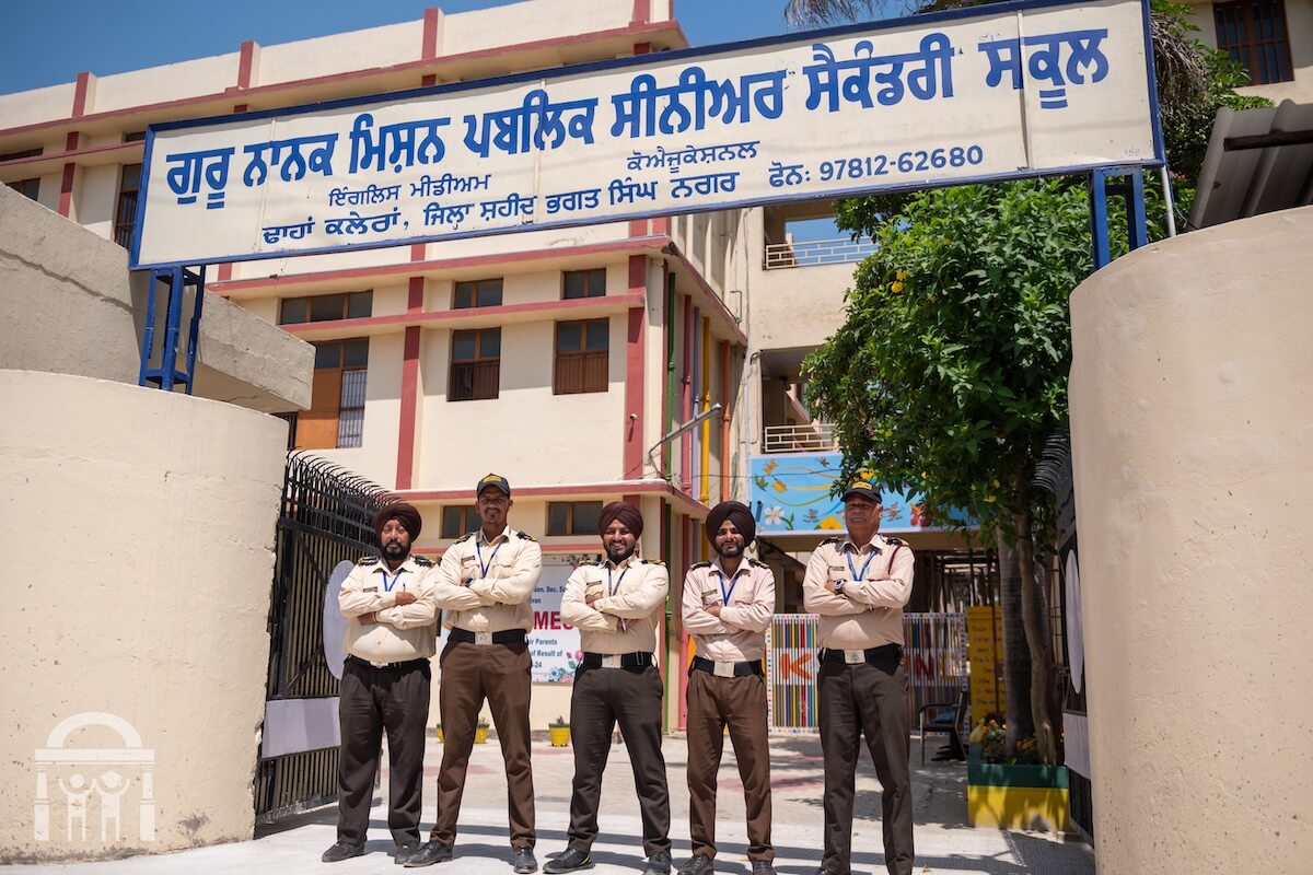 Security guards at gate and sign of Guru Nanak Mission Public School in Dhahan Kaleran Punjab